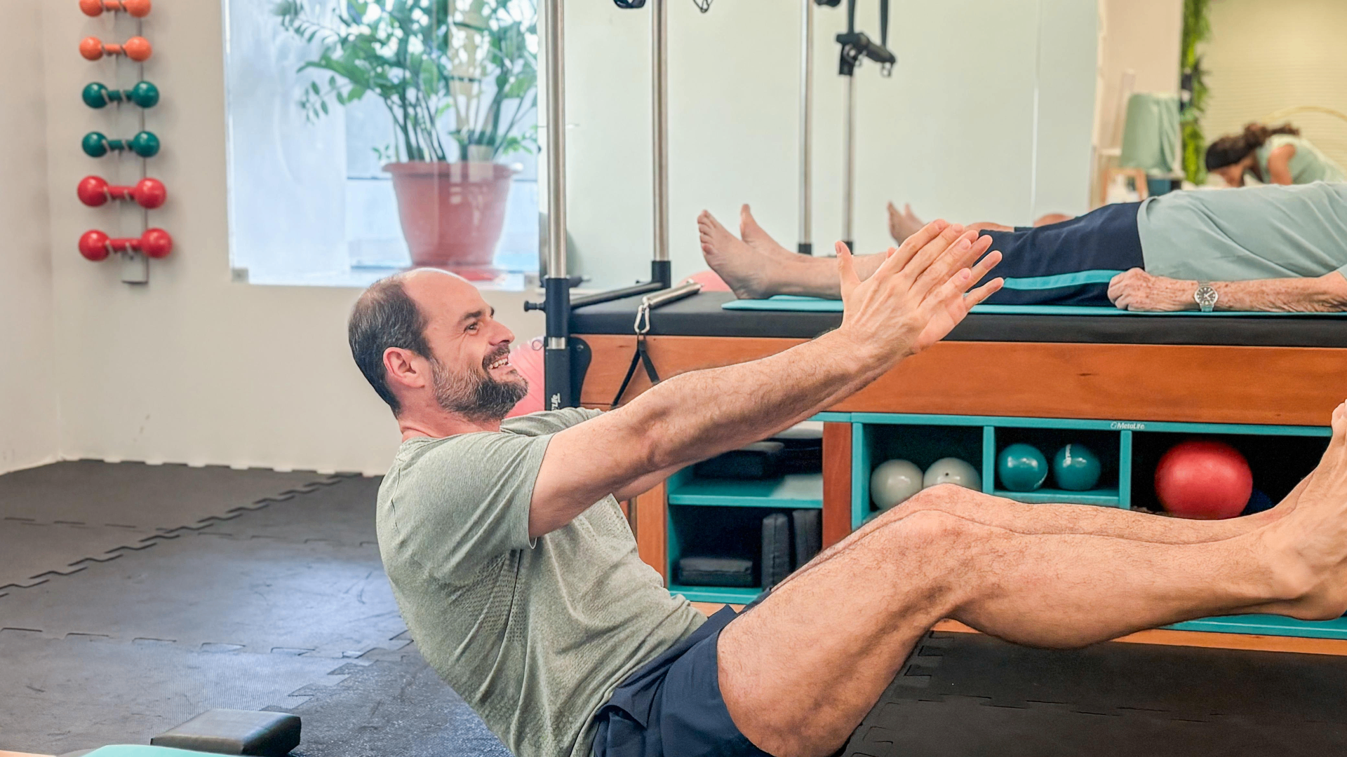 Aluno sorrindo durante exercício de Pilates